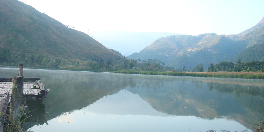 Scenic view of Shilloi Lake in Phek, Nagaland, surrounded by lush green hills and forests.