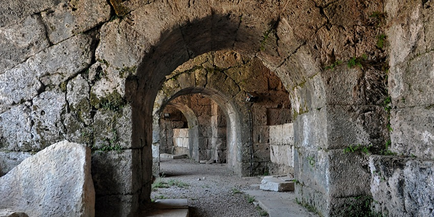 A picture of Side Ancient theatre with views of the turquoise Mediterranean Sea in the background.