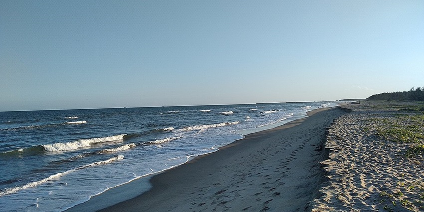 Golden sunlight glows on Silver Beach as gentle waves kiss the shore in the afternoon.