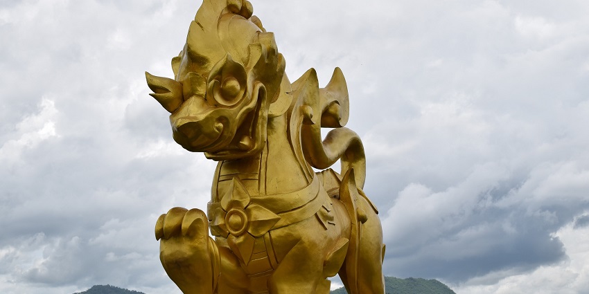 Scenic view of Singha Park, with tea plantations and a golden lion statue.