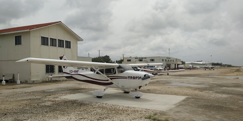 Sir Barry Bowen Municipal Airport in Belize with propeller aircraft and airport buildings