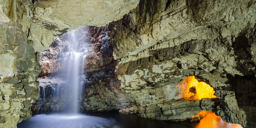 Experience the beauty, where flowing water meets ancient rock among waterfall caves.