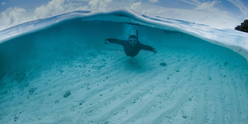An image of the clear blue waters of Bechiyal Lagoon and dotted with coral reefs.