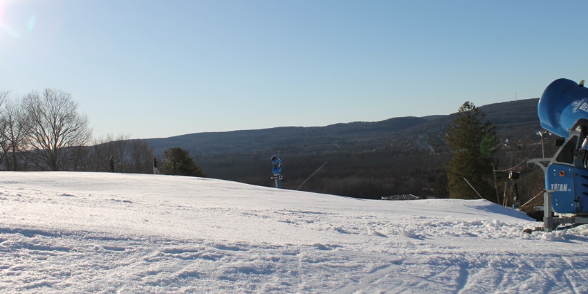 A landscape covered in sheets of white snow and a blue, clear sky stretches above