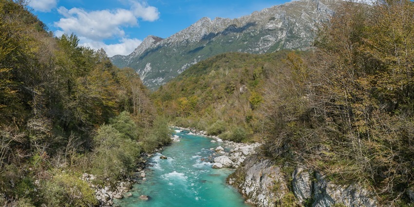 The Soca River flows through rolling hills and lush greenery, offering scenic views.