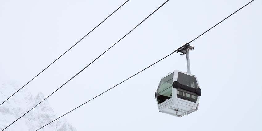A professional skier is gliding down the snowy slope while skillfully manoeuvring.