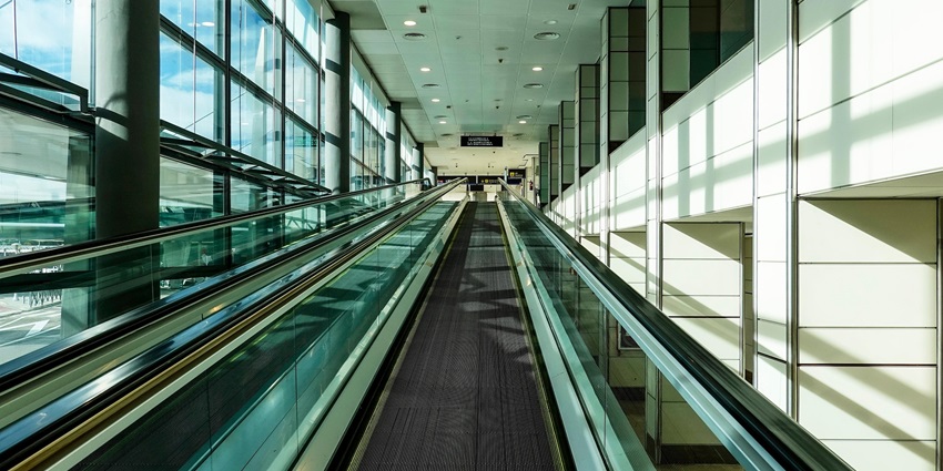 Inside an airport with the sunlight pouring in from the glass panels on the left side