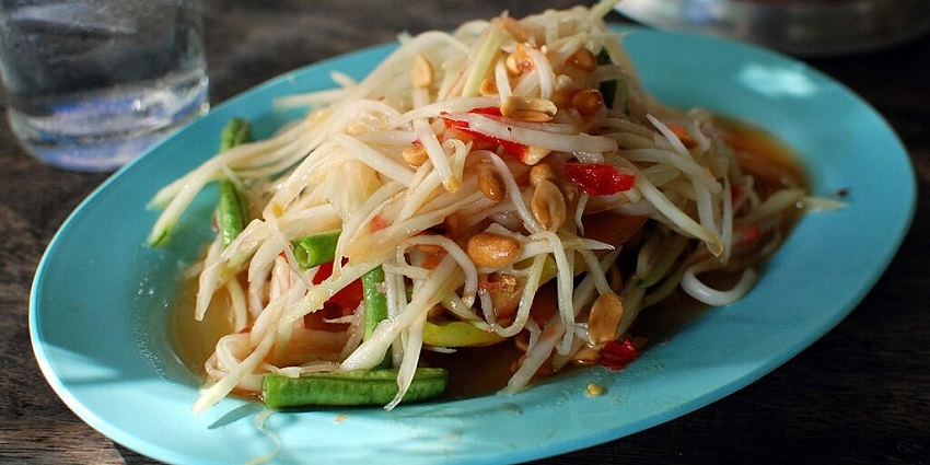 Spicy and tangy green papaya salad with fresh herbs and peanuts, best food in Krabi