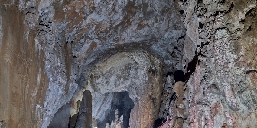 An image of Sơn Đoòng Cave in Vietnam, showcasing its massive chamber with lush greenery and natural light.