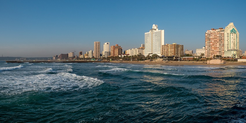 Families enjoying safe swimming and relaxing, wondering what to wear at Durban Beach.