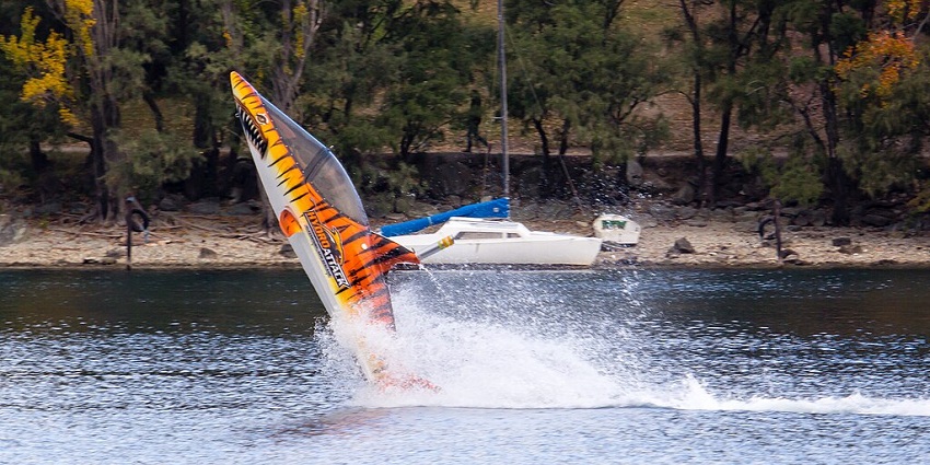 Image of a shark-themed jet boat performing an adrenaline-pumping stunt on the water.