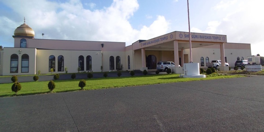Gurudwara Guru Ravidass Temple with multiple vehicles parked on the entrance and gumbad