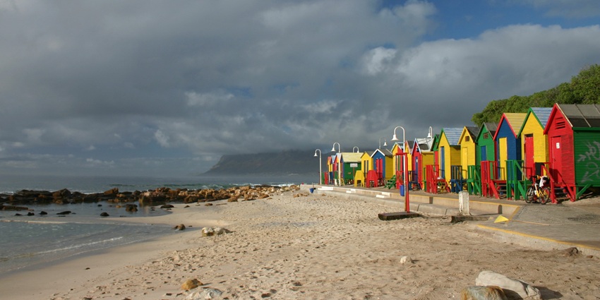 Beach huts at St James Beach near Muizenberg Beach Cape Town, with gentle waves.