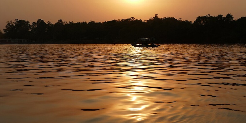 Sukhna Lake, a beautiful reservoir in India, during the sunset with a boat over it