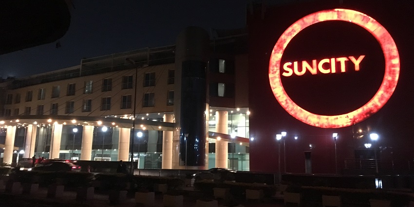 Sun City Mall Cairo at night, glowing with bright lights and its name shining on the right side