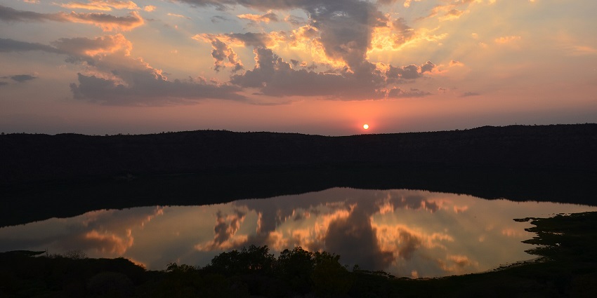 An enchanting picture showcasing the sunrise from the shores of Crater Lake in India.
