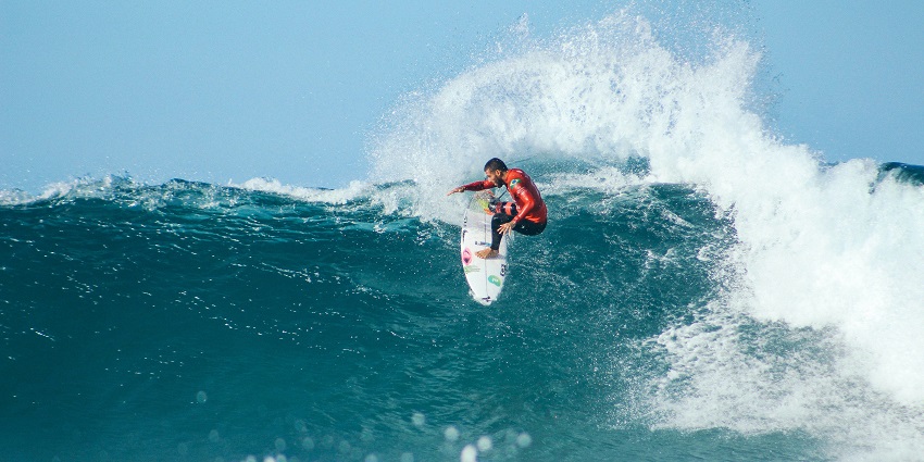 View of a man surfing, one of the most exciting adventure sports in the world to try.