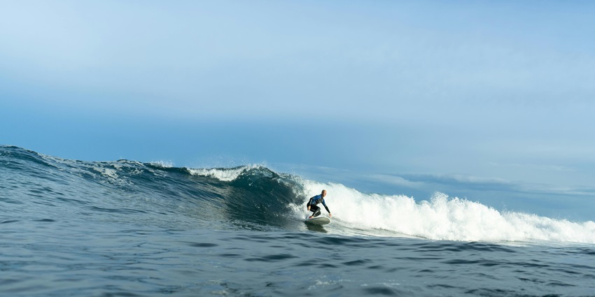An image of surfers catching waves at The Pass, one the Bay’s popular surf spots.
