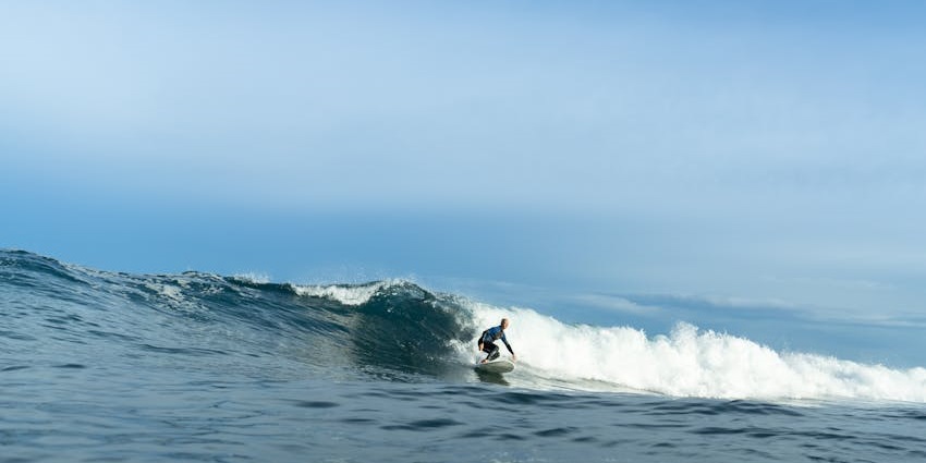 A glimpse of a man surfing on the gushing waves of Arugam Bay Beach, Sri Lanka.