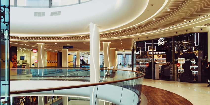 Spacious shopping mall interior with polished floors, shops, and modern design.