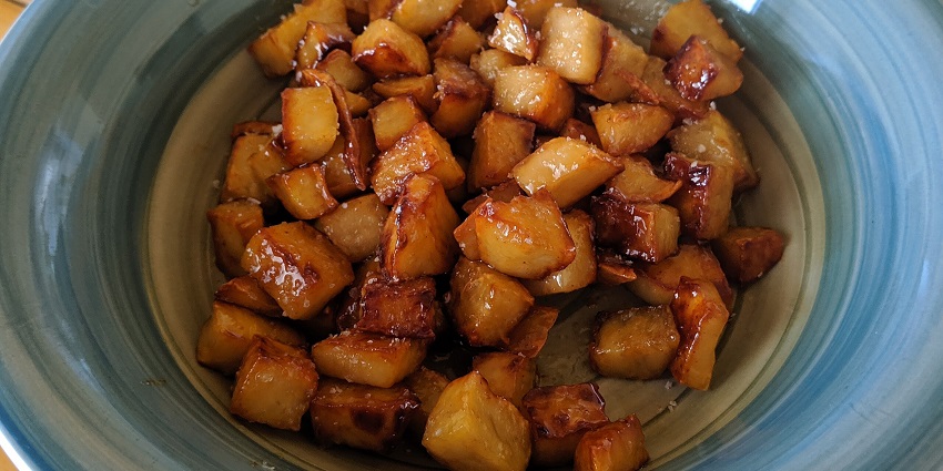 This is an image of a bowl of chopped sweet potato that has been sauteed with honey.