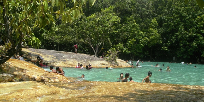 Visitors enjoying a swim in the Emerald Pool Krabi, its waters glowing with stunning green hues