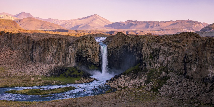 image showing a waterfall flowing through mountains, similar to Tada Roung Chan Waterfall