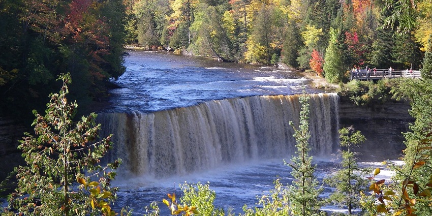 A scenic waterfall in Michigan, known for its golden-brown waters and forested surroundings.