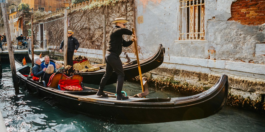 An image of visitors taking a boat ride in the tranquil ponds of Taman Ujung Water Palace.