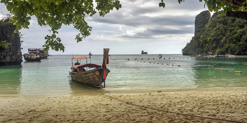 A long tail boat is waiting for the passengers at the coast of Railay Beach, Thailand.