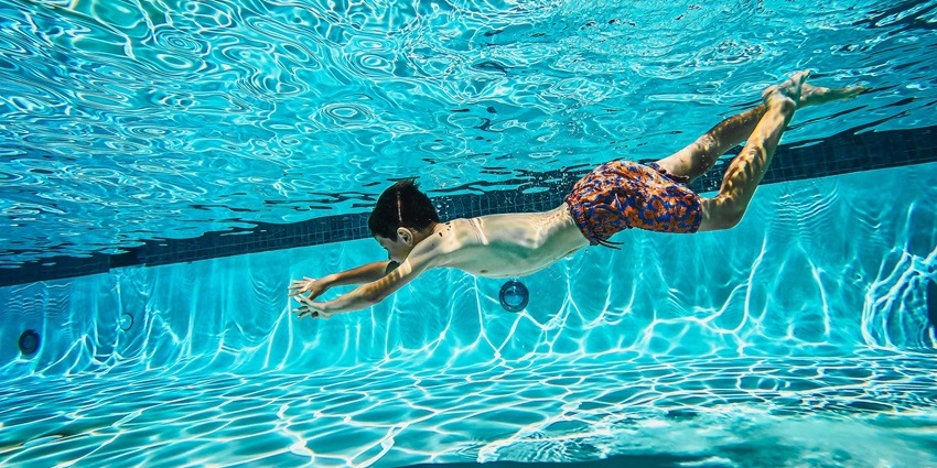 Image of a kid swimming and diving in a pool - one of the best things to do in Maldives learn a diving course