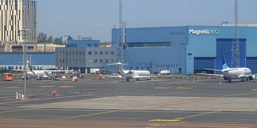Busy Tallinn Airport runway with multiple aeroplanes and airport vehicles in motion