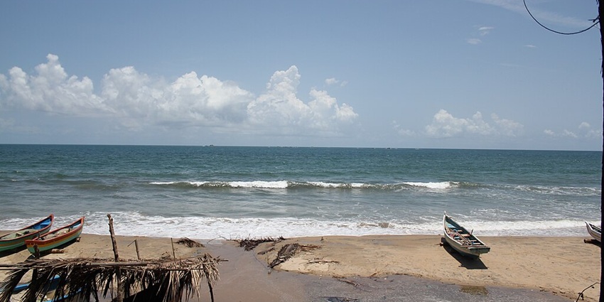 An image of Tarkarli Beach, Maharashtra, with gentle waves and a wide sandy shore.