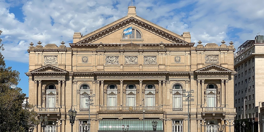 The Teatro Colon building amidst a well-maintained garden shows the legacy of historic opera.