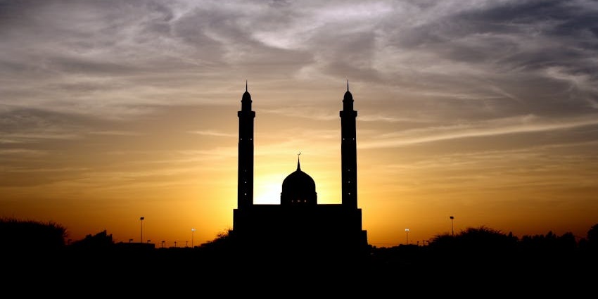 An image of a woman praying in a mosque which resembles the Khai Mosque in Vietnam