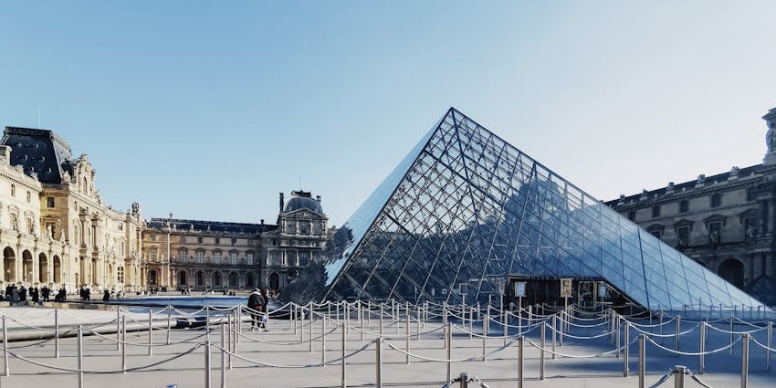 A stunning view of the Louvre Museum in Paris, showcasing its grand architecture and glass pyramid.