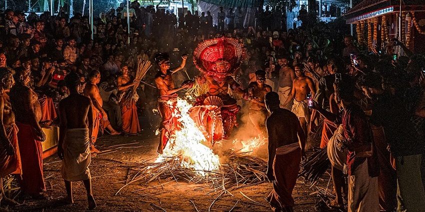 An image of a Theyyam performer in full costume and makeup in Perumthitta Tharavad Kottamkuzhy Theyyam