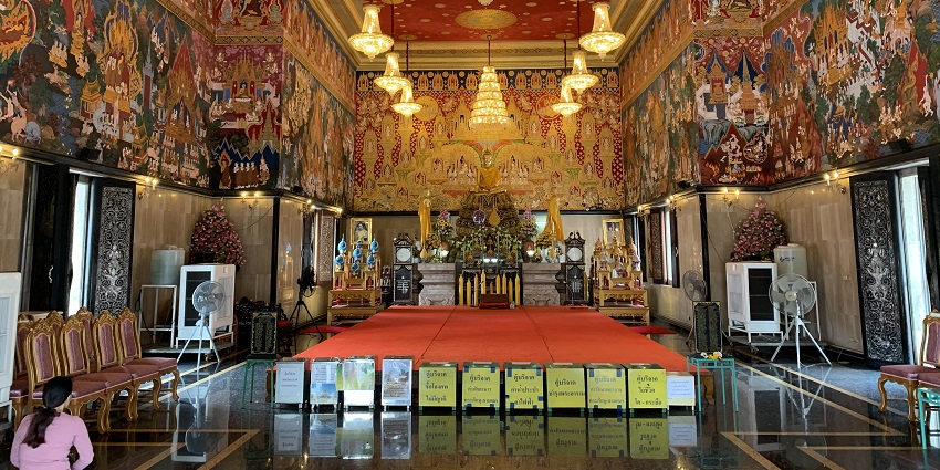 Photograph of tourists walking on the intricately decorated grounds of Wat Hua Lamphong in Bangkok.
