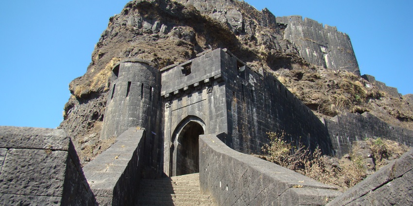 Entrance to the Tikona fort with old architecture, black stone walls
