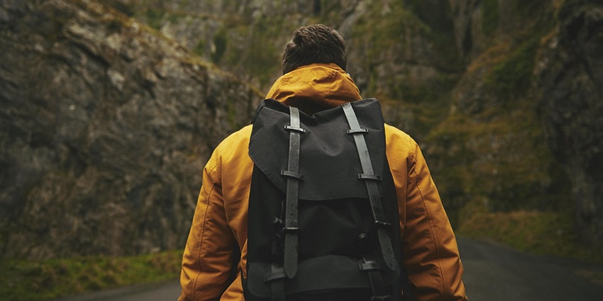 image of a man with a backpack trekking on a rugged trail similar to Ranthan Kharak Trek.