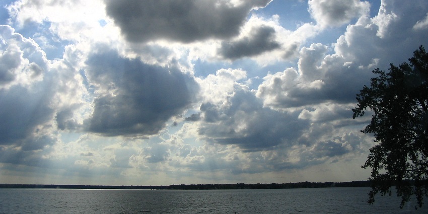 The deepest lake in Michigan with a large water body and distant shoreline under a cloudy sky.