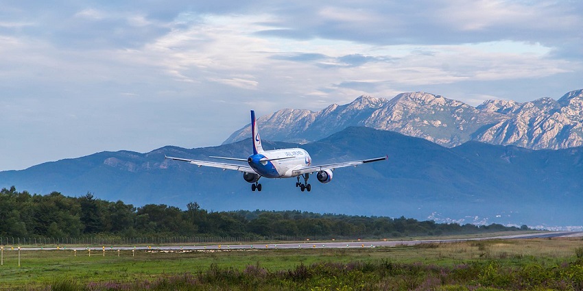 Passengers are waiting in queues at the modern check-in counters of Tivat Airport