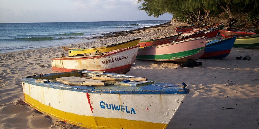 Waves gently roll onto Tofo Beach as fishing boats rest on the sun-kissed shore of one of the best beaches in Africa.