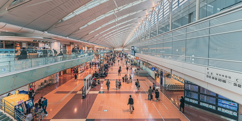An image of Haneda International Airport in Asia, showing airplanes, terminals, and a busy tarmac