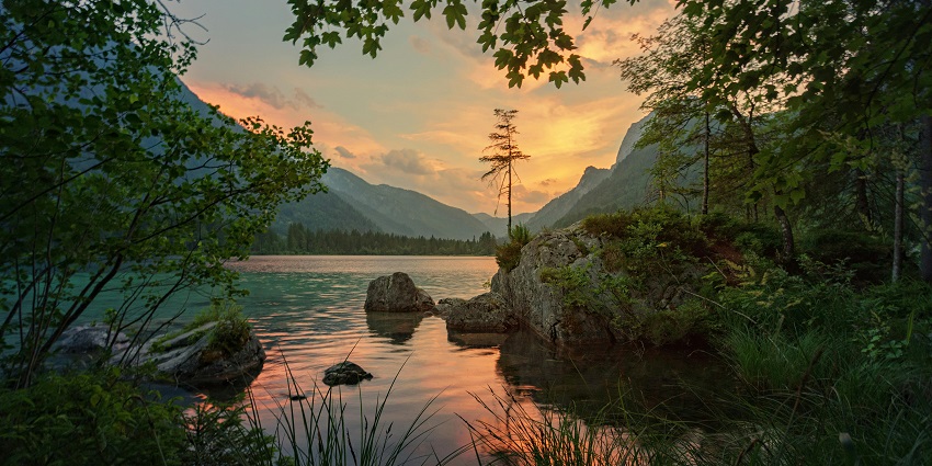 Serene lake mirrors the surrounding trees and sky, creating a breathtaking natural view
