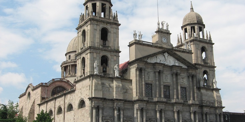 Toluca Cathedral, with its fine architecture and statues and cars parked outside