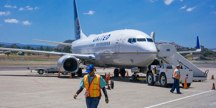 United Airlines plane at Toncontín Airport, Tegucigalpa, with ground crew nearby.