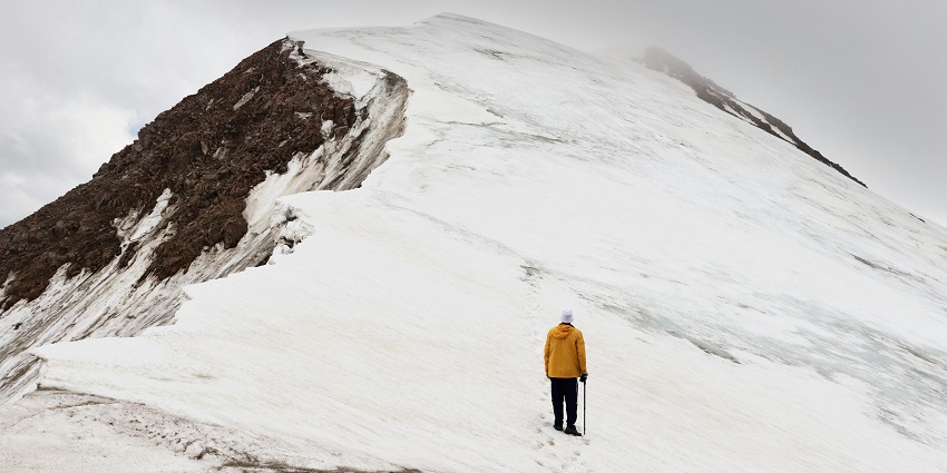 Image of a man climbing the snow covered trails of Torres Del Paine Peak.