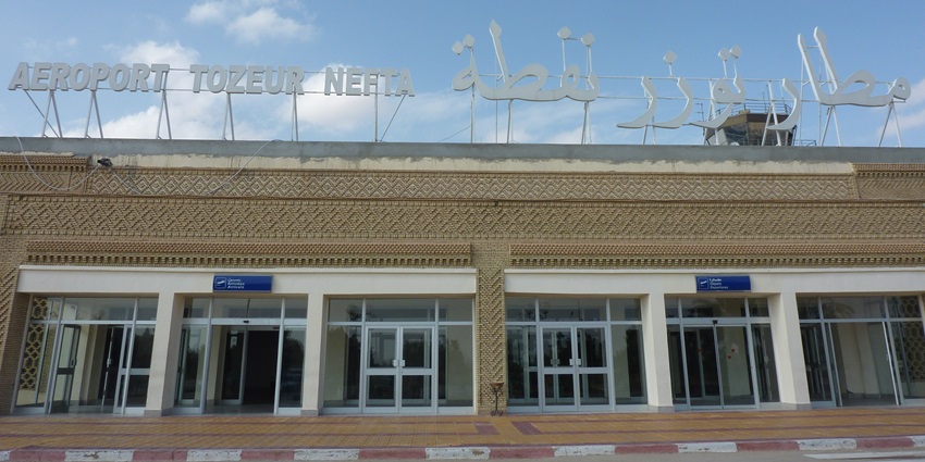 Tozeur-Nefta International Airport with the golden facade, name displayed in English and Urdu