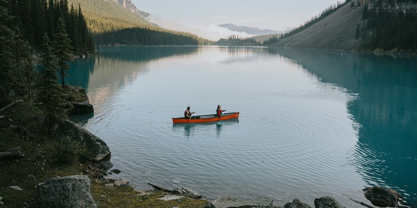 People canoeing at the only floating lake in the world surrounded by majestic peaks.